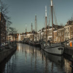 Ein Kanal in der niederländischen Stadt Groningen, in dem sich mehrere Segelschiffe befinden.