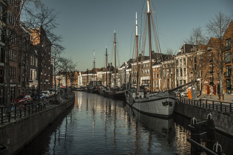 Ein Kanal in der niederländischen Stadt Groningen, in dem sich mehrere Segelschiffe befinden.